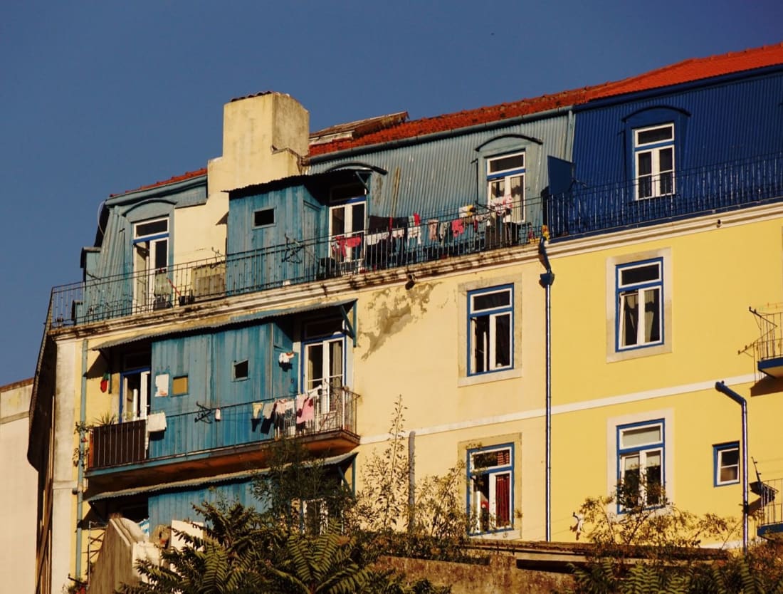 Colourful Mouraria façades with laundry drying on the balconies in afternoon light