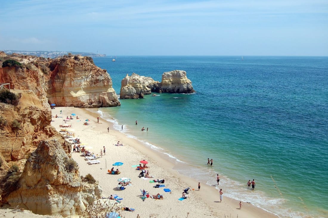 Sunbathers and parasols on Praia da Rocha at Portimao in high summer