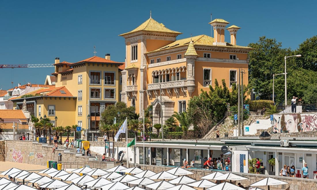 Sunbeds and the ornate villas above Praia da Conceição in Cascais