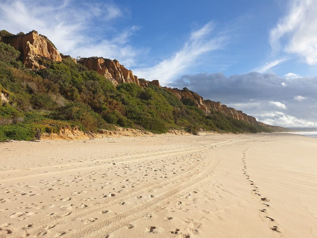 Empty sand below the ochre fossil cliff on the southern Costa da Caparica